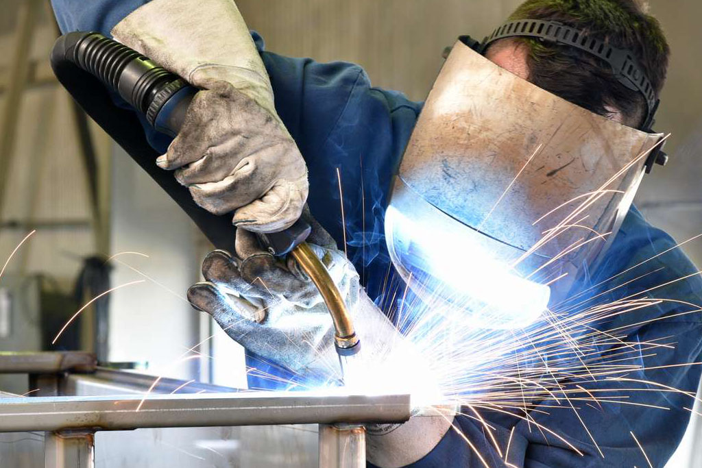 welder works in metal construction - construction and processing of steel components